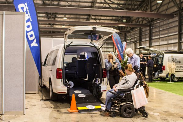 Volkswagen Caddy demonstration on the exhibition floor. Woman in wheelchair is testing out the vehicle