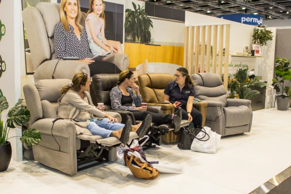 A group of visitors sitting on lounges on Brisbane Expo floor