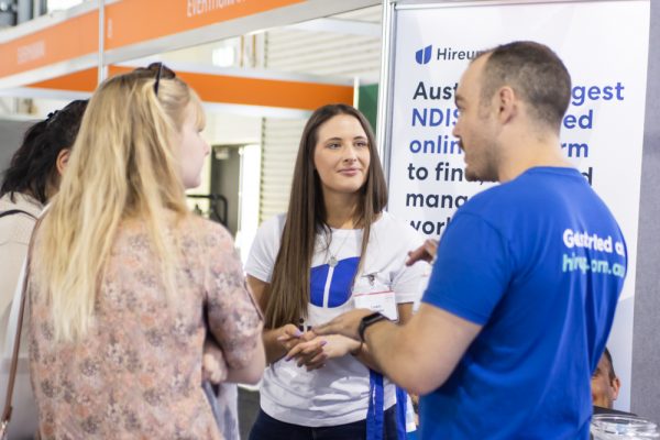 Hireup exhibitors talking with visitors at their exhibition stand - ATSA Independent Living Expo Canberra
