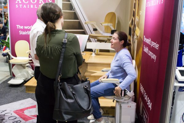 A woman testing out the products at the Acorn Stairlifts ATSA Sydney Expo stand