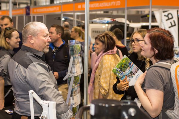 Visitors speaking with exhibitors on expo floor