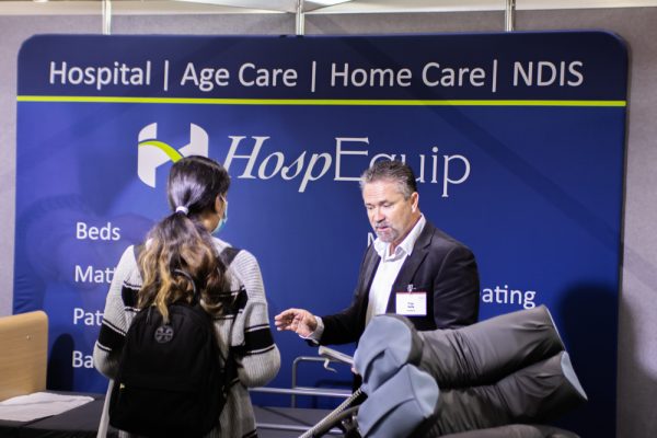 HospEquip staff member speaking to an ATSA Canberra visitor on the exhibition floor