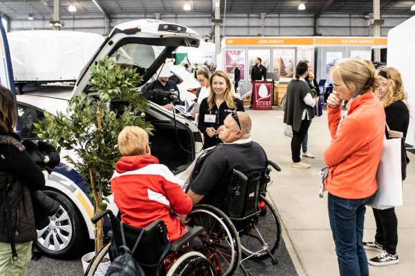 Two wheelchair users looking at an accessible vehicle on the demo floor - ATSA Melbourne image gallery, 2021
