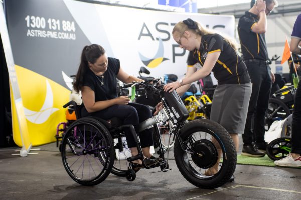 Astris PME staff demonstrating a three-wheeled wheelchair to ATSA visitors - Canberra image gallery, 2021