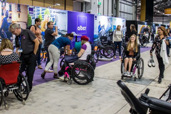 An image of the busy expo floor showcasing a gallery of wheelchair user products